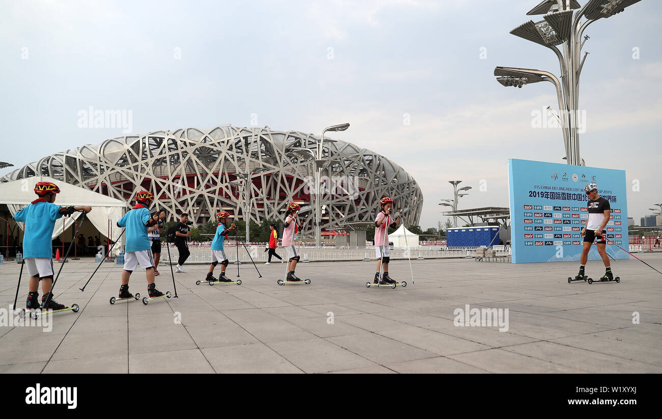 Beijing, China. 4th July, 2019. Johannes Hoesflot Klaebo (1st R) of Norway gives instructions to young rollers after Men's 1500m Sprint Final of 2019 FIS China Beijing Roller Ski World Cup in Beijing, China on July 4, 2019. Credit: Wang Lili/Xinhua/Alamy Live News Stock Photo
