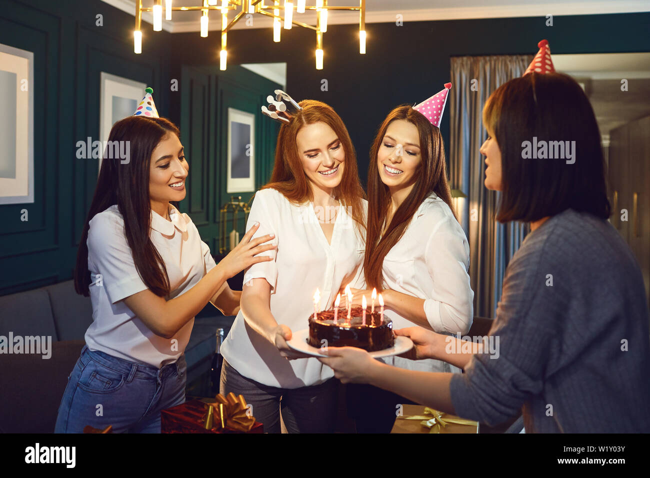 Girlfriends congratulate with cake and candles for a birthday party at home Stock Photo