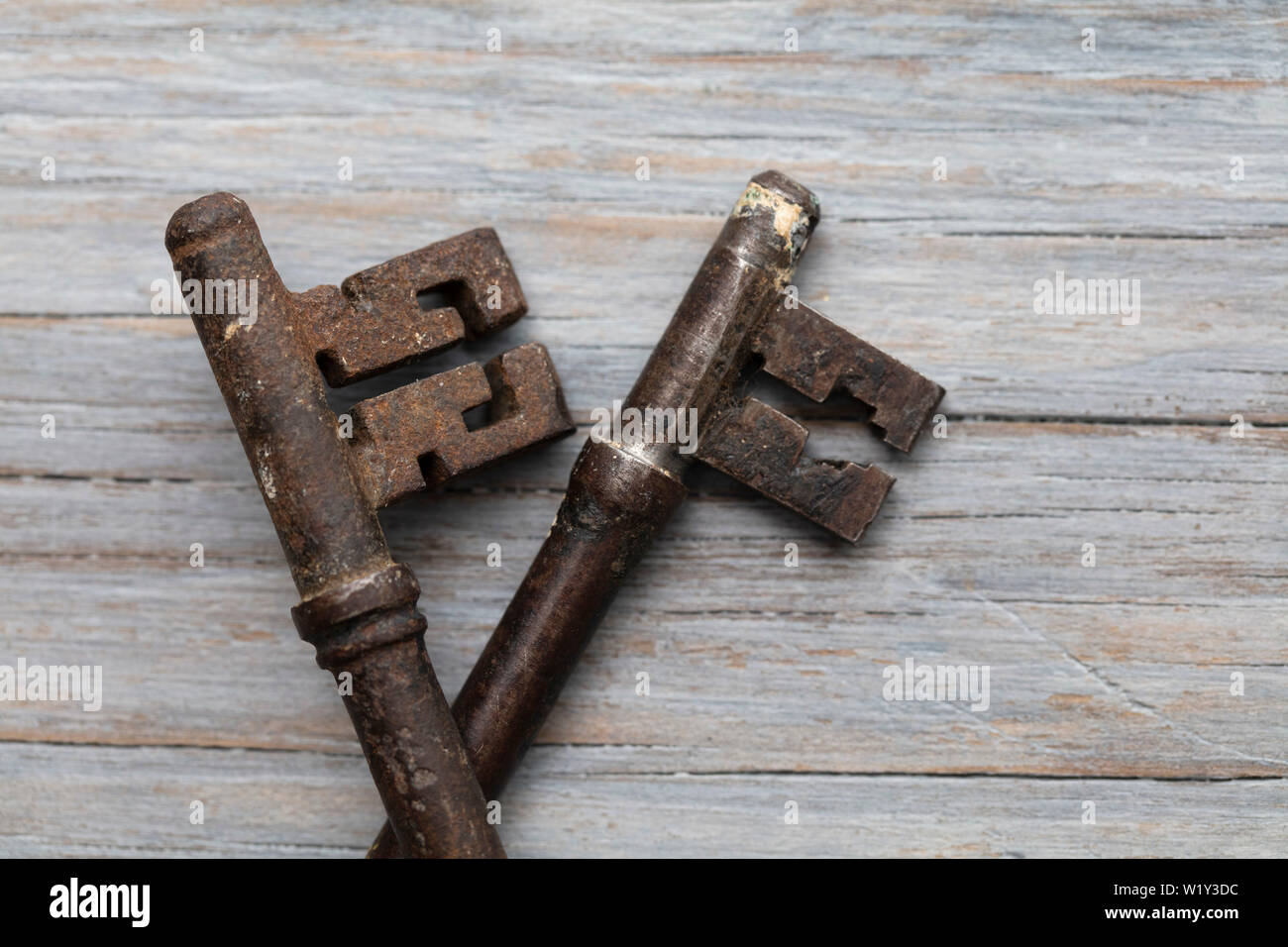 Vintage old fashioned keys on a rustic wooden background. Security concept Stock Photo