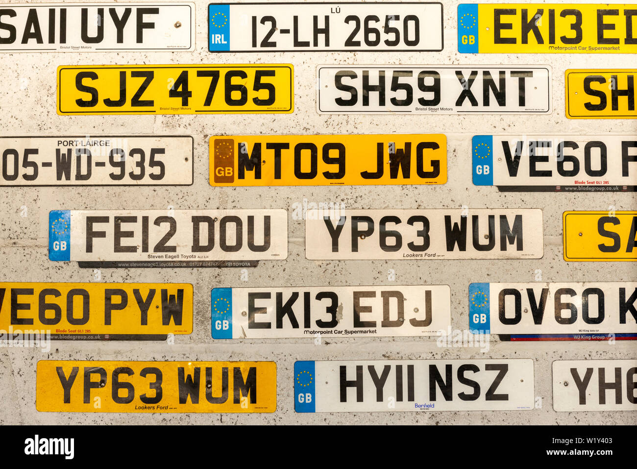 Various old discarded British and Irish license number plates displayed on  car service wall Stock Photo - Alamy
