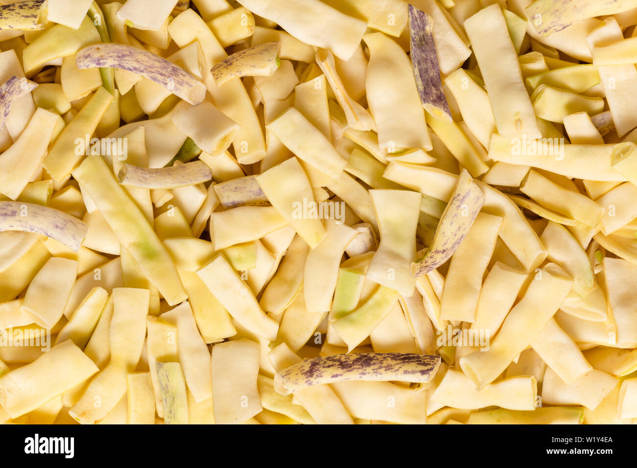 Flat yellow wax beans with one opened bean pod . Stock Photo