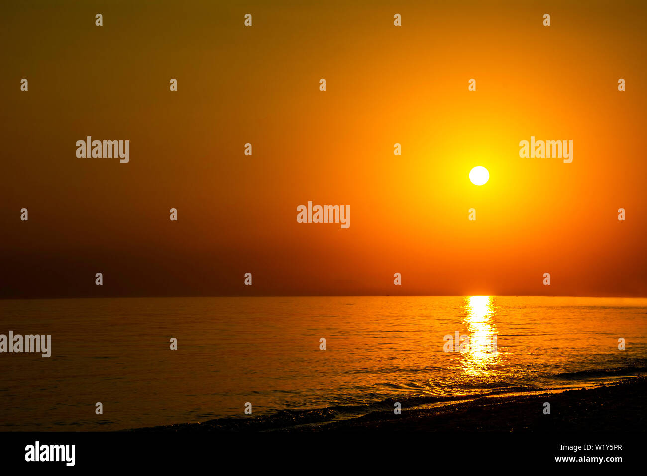 Horizontal sunset coastline calm sea with golden sun - Late afternoon on beach waterline with golden direct sunset calm sea ocean - Sun sky sea ocean Stock Photo