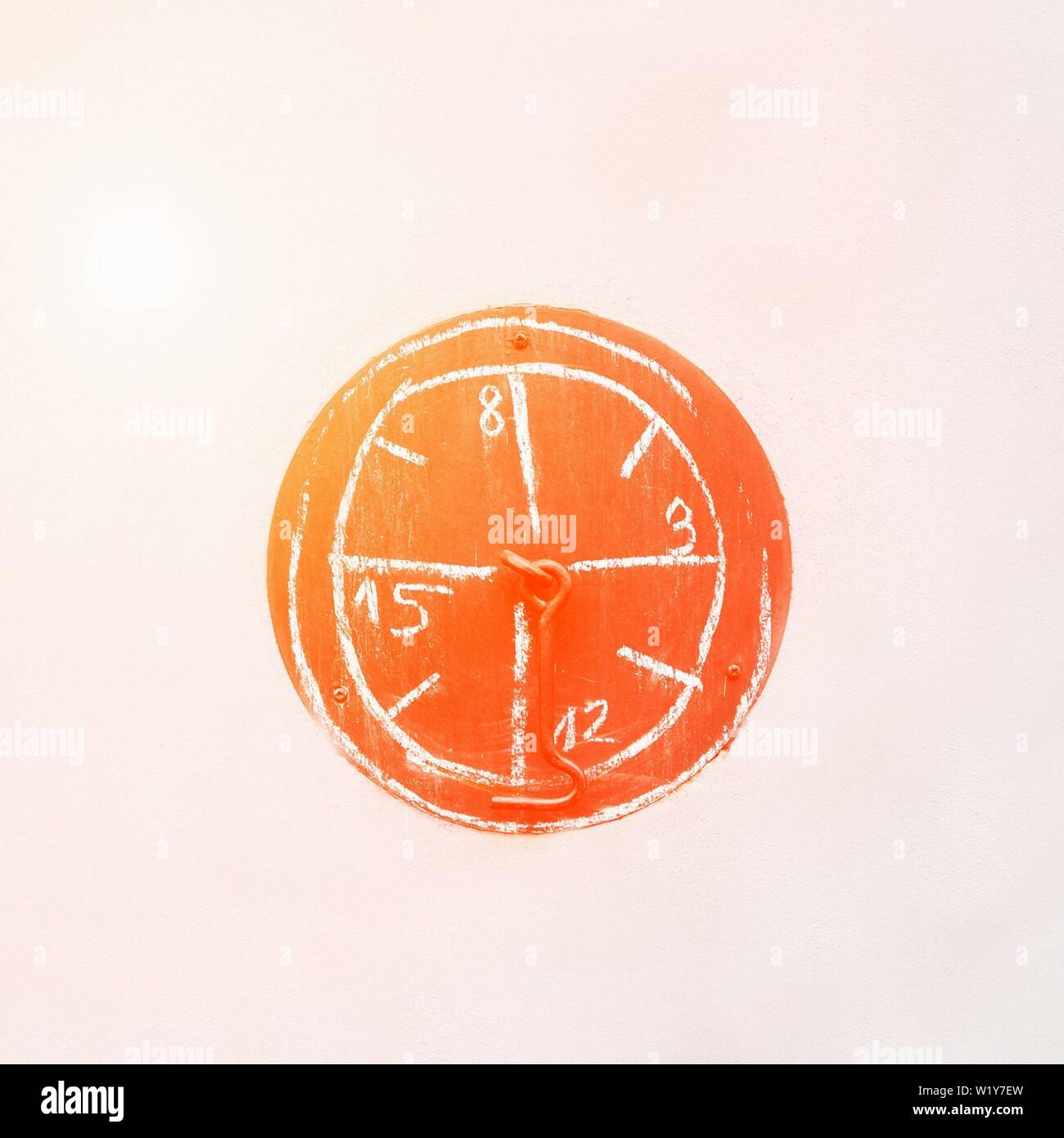 Bright Orange Sunny Watch Sign On The Light Wall Wrong Time