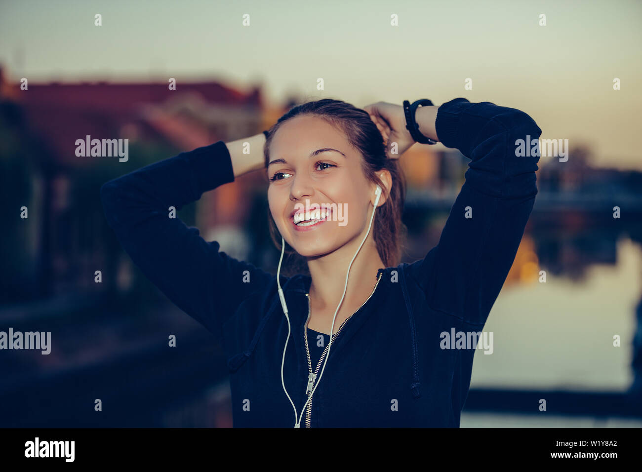 Beautiful Sporty Girl Tying Hair Before Her Workout On The Bridge