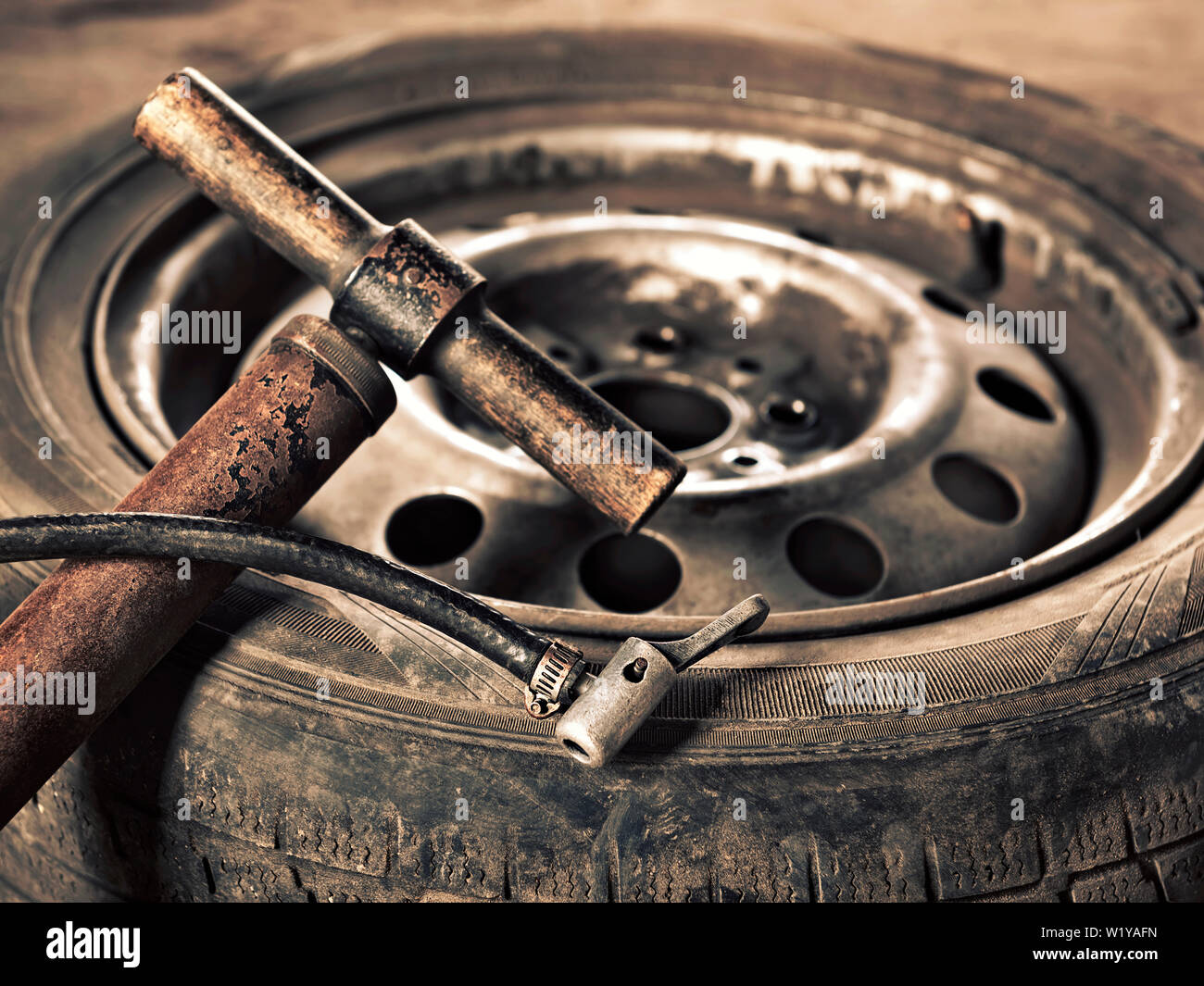 old hand-pump and car wheel close-up Stock Photo