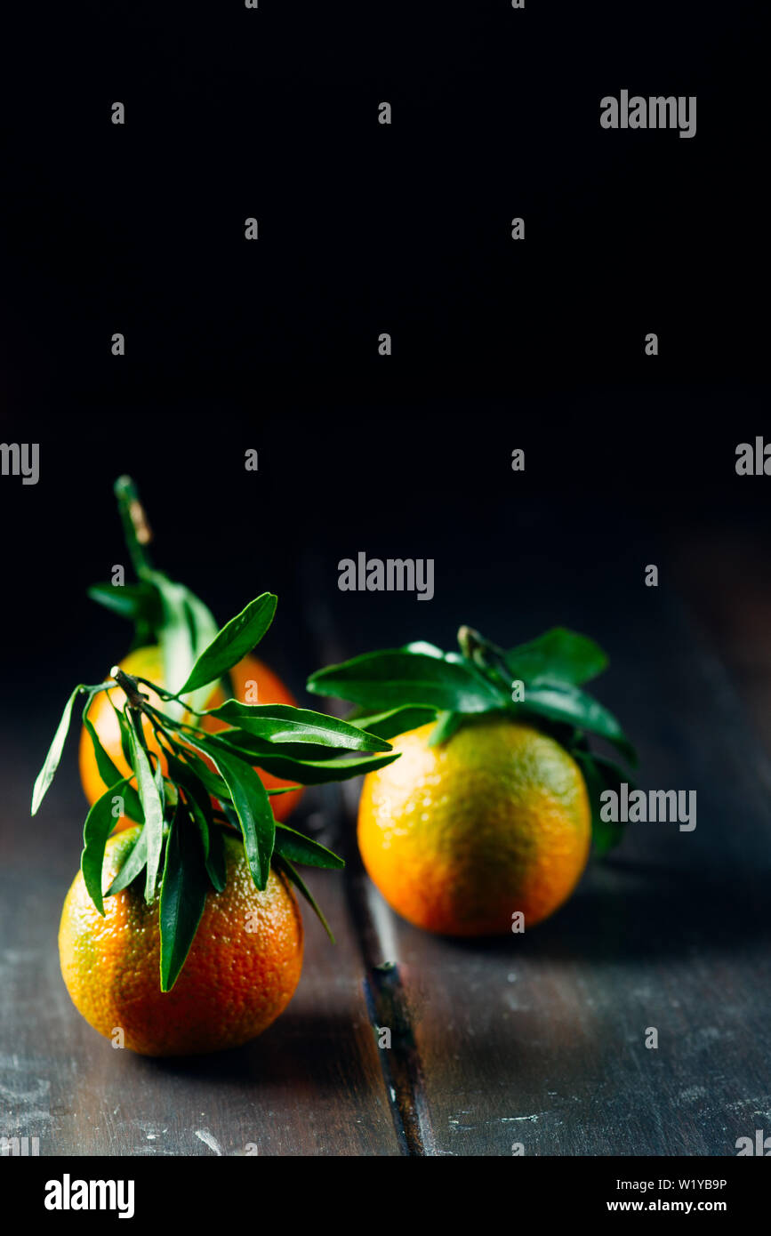 Satsuma Tangerine with Leaf  on a wooden table, dark tone, Stock Photo