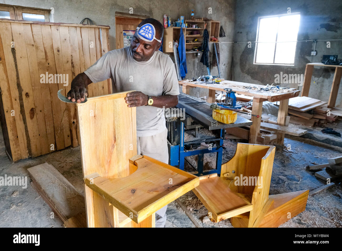 Carpenter manufactures special chairs for handicapped children. Iwindi Rehabilitation Center in Mbeya, Simama project in Mbeya, Tanzania. Stock Photo