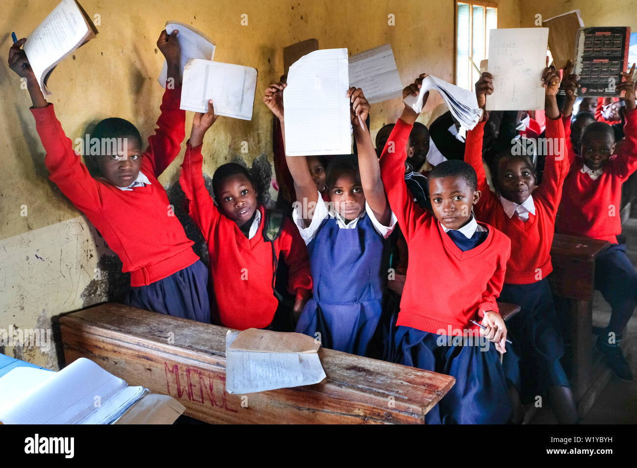 Students in red school uniforms in a school class of the Mwenge Primary School in Mbeya, Tanzania Stock Photo