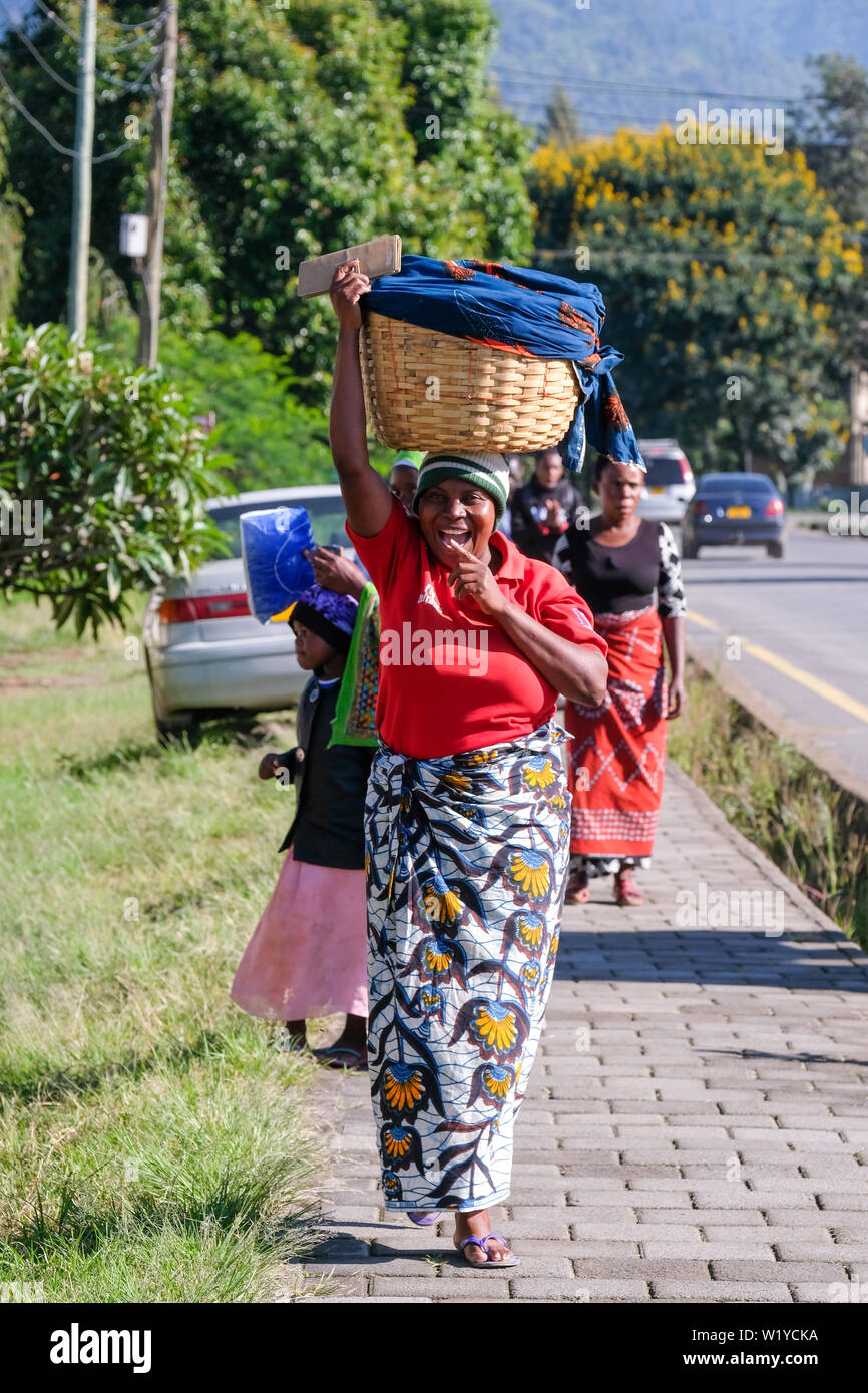 Trader with head load in Mbeya, Tanzania., Africa   ---   Händlerin mit Kopflast in Mbeya, Tansania. Stock Photo