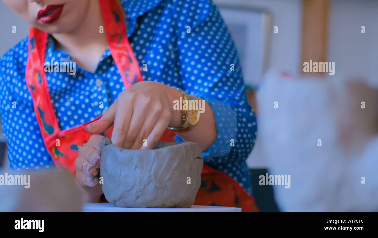 Woman making mug in pottery studio workshop Stock Photo