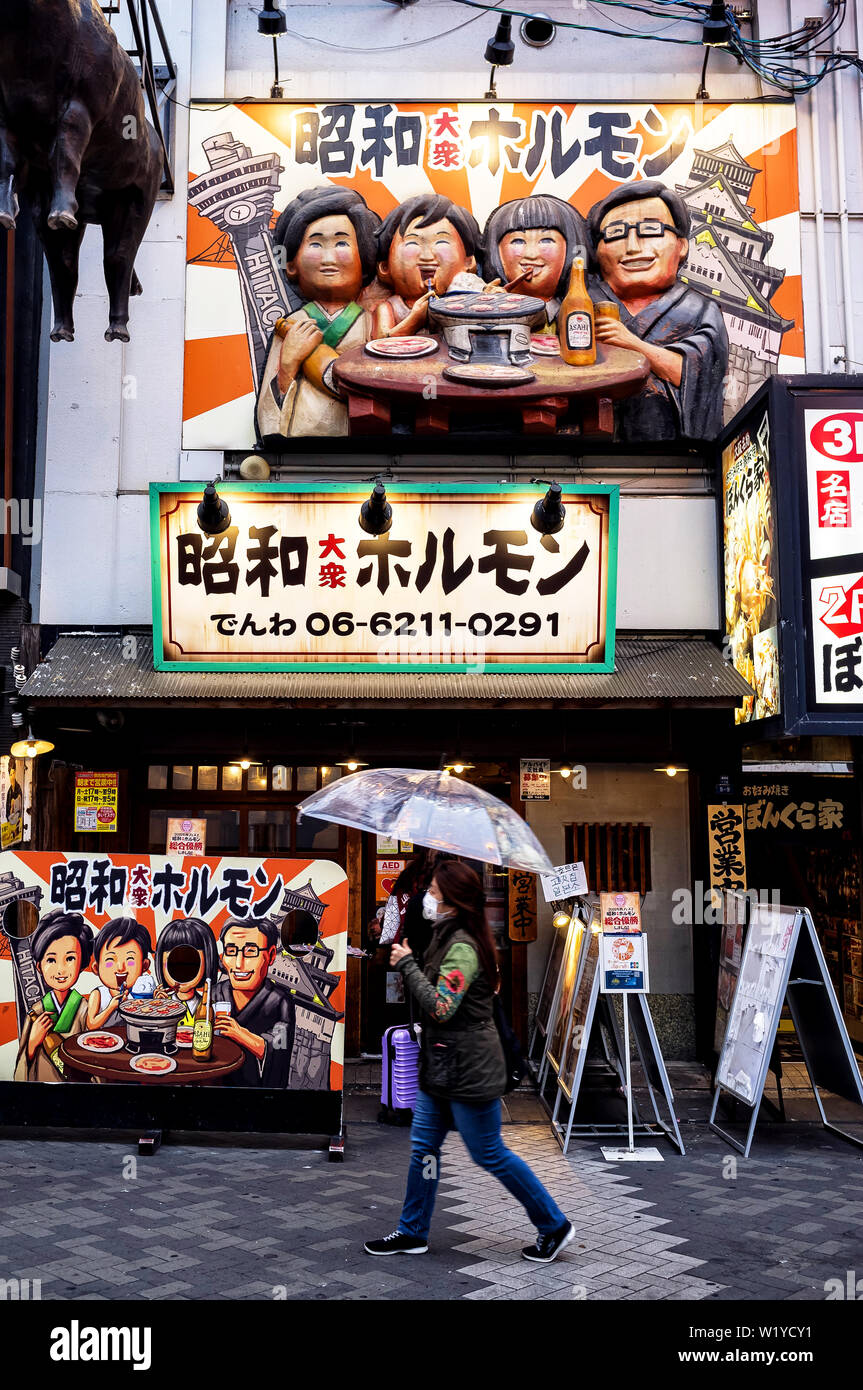 April 17, 2019: Woman walking in front of a restaurant in Osaka, Japan Stock Photo