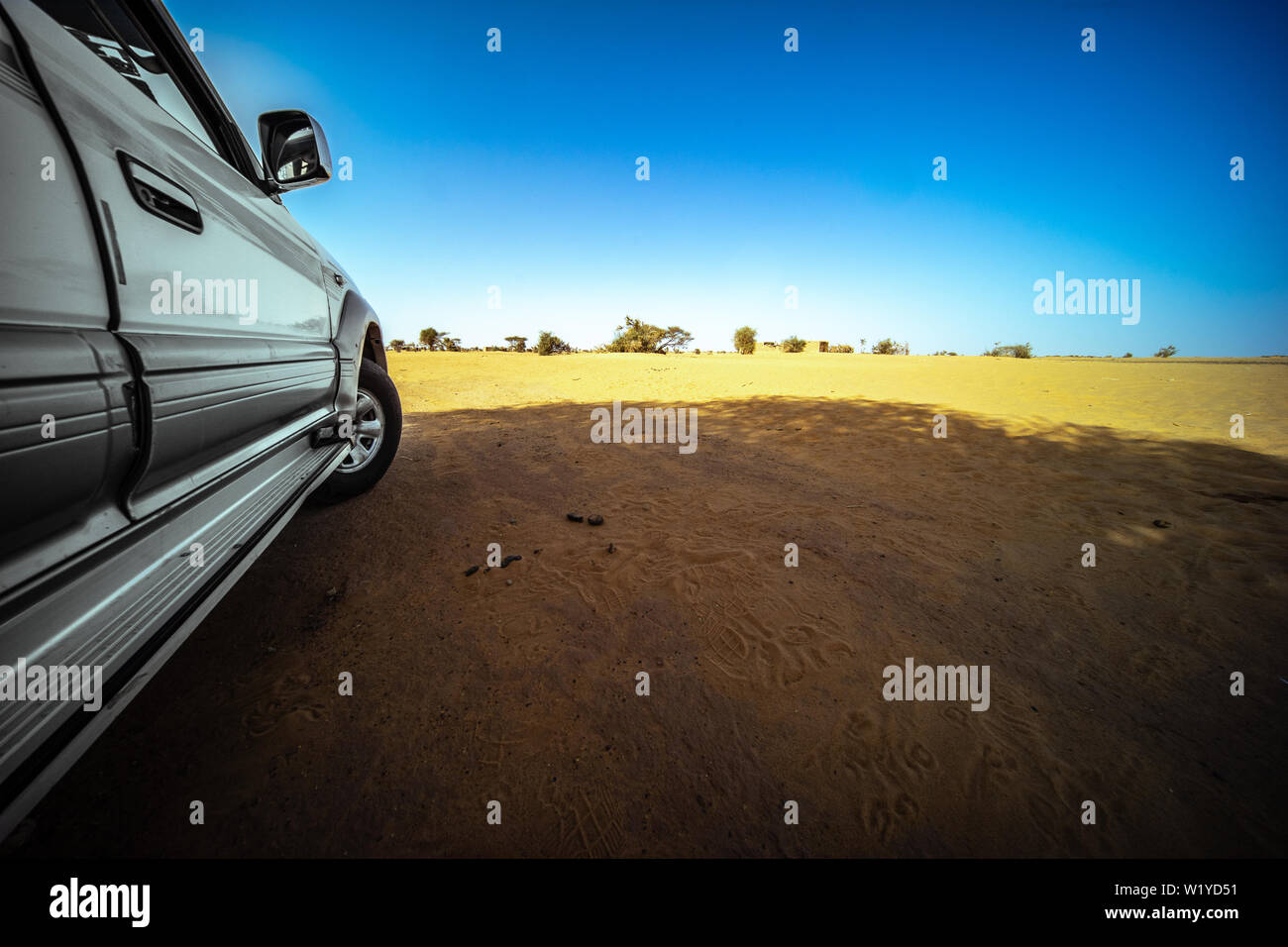 Off-road vehicle parked in the shade in the hot dry Sahara desert, Sudan Stock Photo