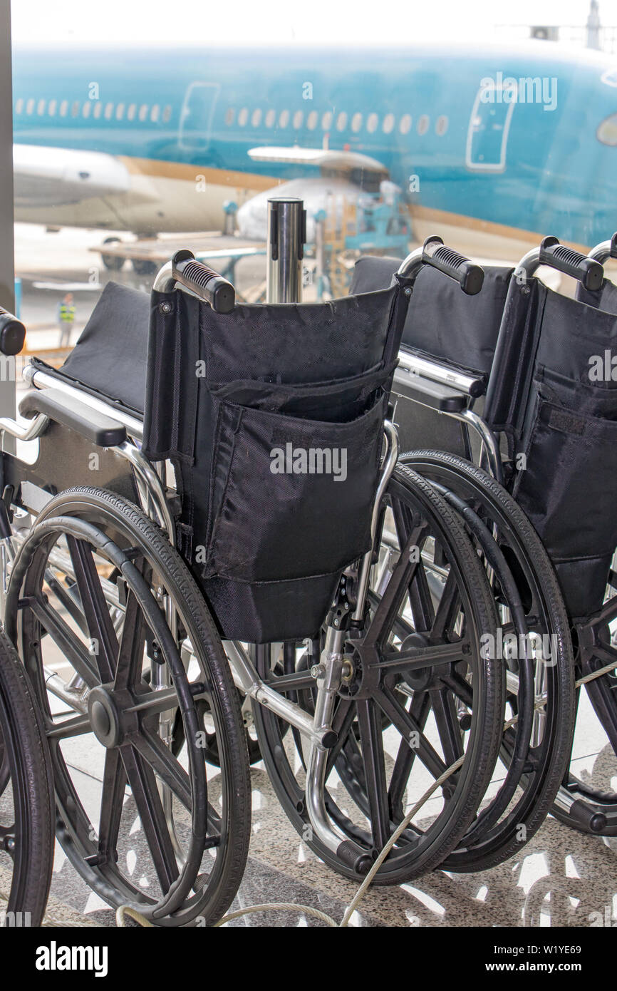 Line of handicapped wheelchairs ready in the airport terminal Stock