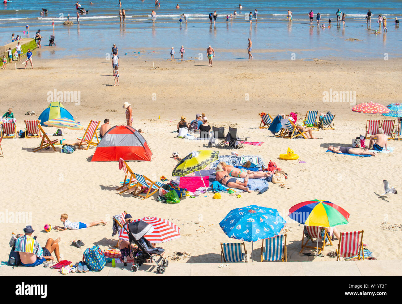 Lyme Regis, Dorset, UK. 4th July 2019. UK Weather: The beach at the seaside resort of Lyme Regis was busy this afternoon as sunseekers enjoyed the scorching hot sunshine and blue skies. Credit: Celia McMahon/Alamy Live News. Stock Photo