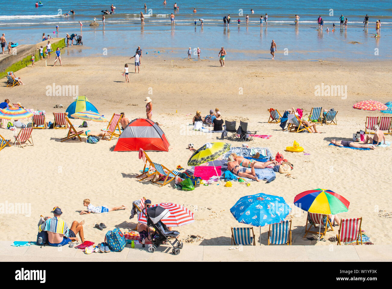 Lyme Regis, Dorset, UK. 4th July 2019. UK Weather: The beach at the seaside resort of Lyme Regis was busy this afternoon as sunseekers enjoyed the scorching hot sunshine and blue skies. Credit: Celia McMahon/Alamy Live News. Stock Photo