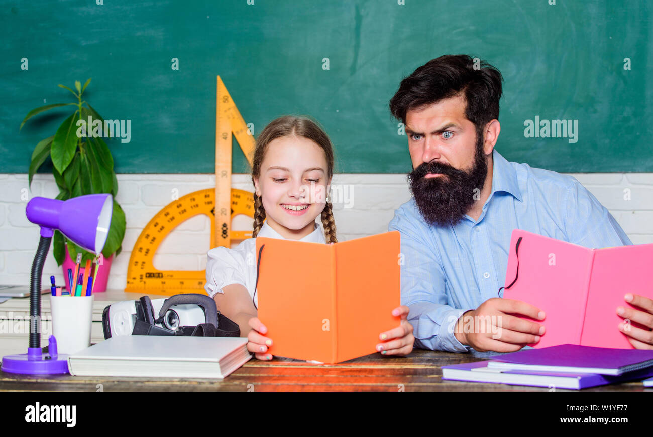 Concentrated on studying. small girl child with bearded teacher man in classroom. daughter study with father. Teachers day. back to school. Private teaching. knowledge. Home schooling. private lesson. Stock Photo