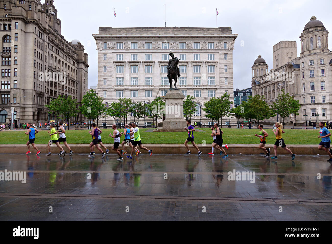 Competitors taking part in the 2019 Rock n Roll Marathon running past Liverpool's historic waterfront buildings. Stock Photo