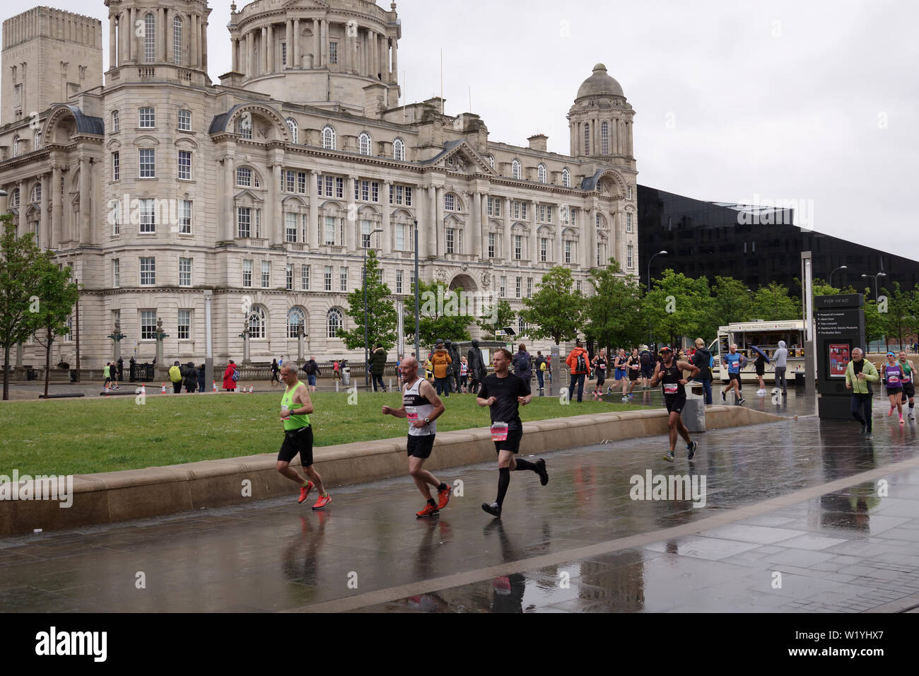 Competitors taking part in the 2019 Rock n Roll Marathon running past Liverpool's historic waterfront buildings. Stock Photo