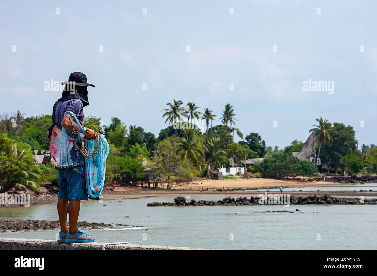 Man holding fishing nets Background sea and sky Stock Photo - Alamy