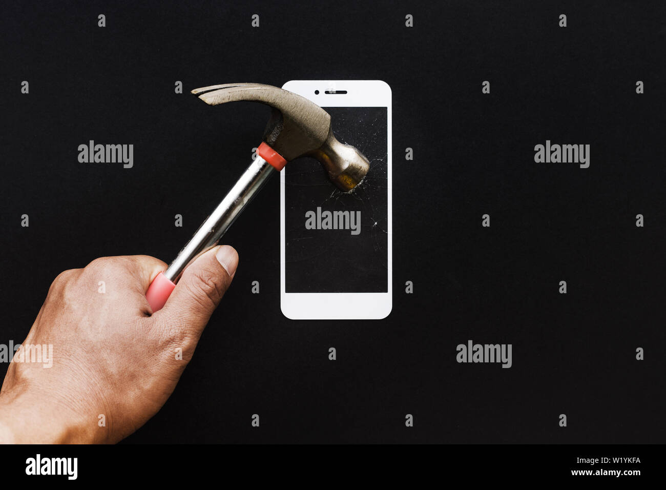 Male hand with hammer on tempered glass shield or film screen cover