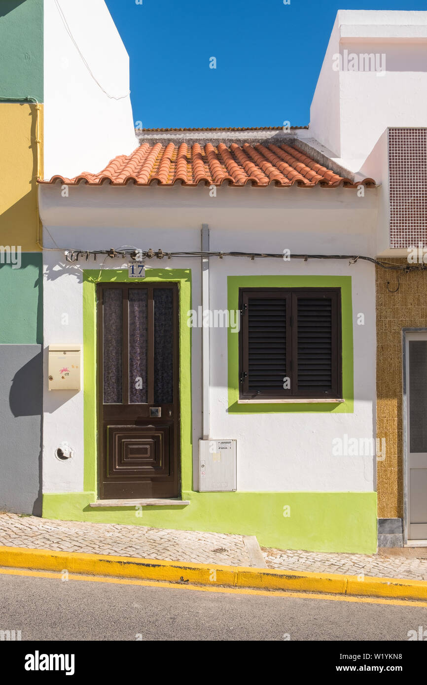 Very small house painted white and lime green in Alvor, Algarve, Portugal Stock Photo