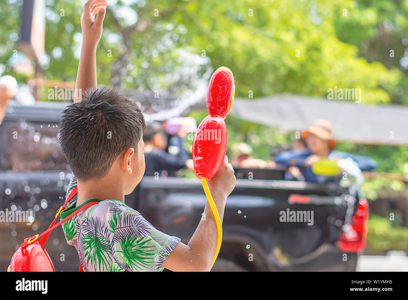 Asian boy holding a water gun play Songkran festival or Thai new year in Thailand. Stock Photo