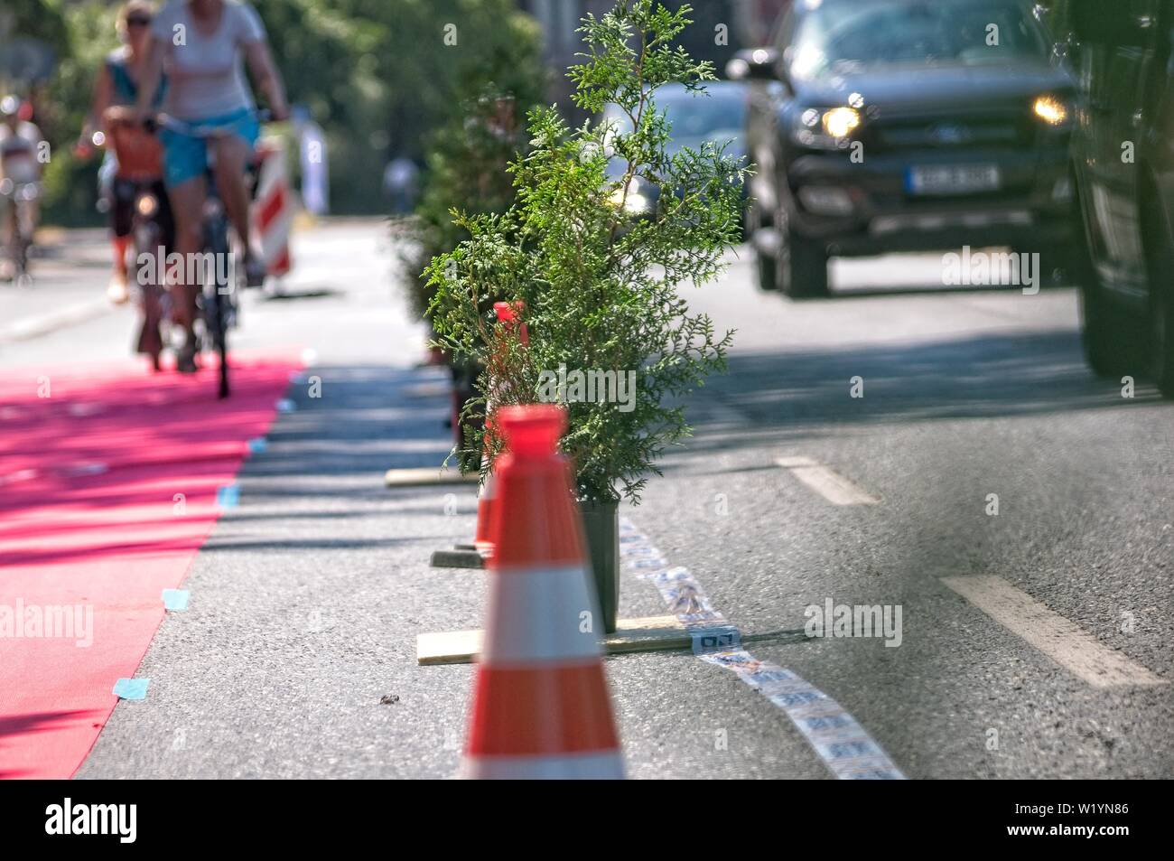 A protected bike lane separated from the traffic with pylons and plants Stock Photo