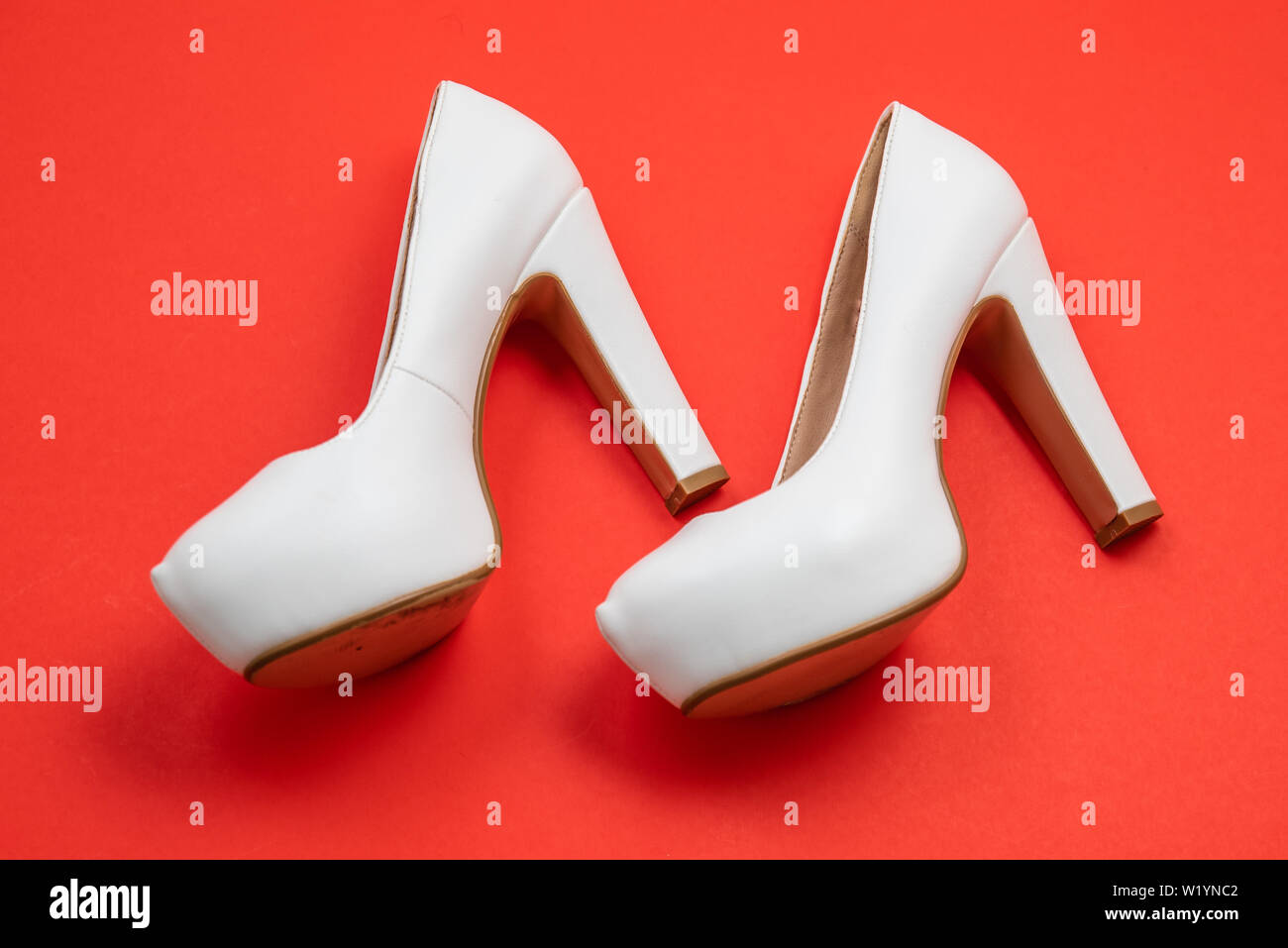White high heeled shoes on red background - top view concept - blank empty room space for text or copy. Suitable for holidays like Valentine's or Chri Stock Photo