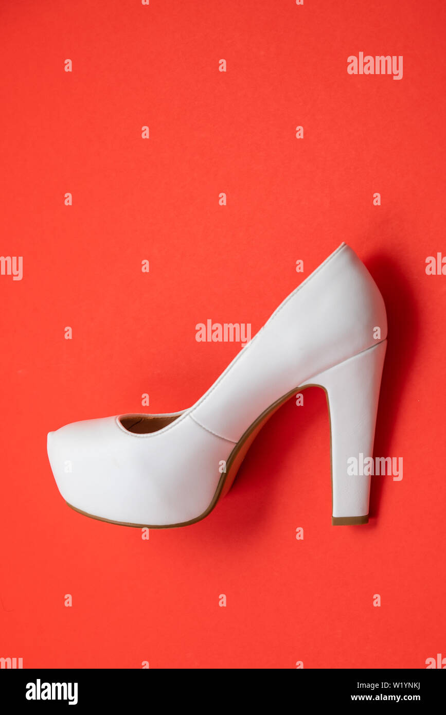 White high heeled shoes on red background - top view concept - blank empty room space for text or copy. Suitable for holidays like Valentine's or Chri Stock Photo