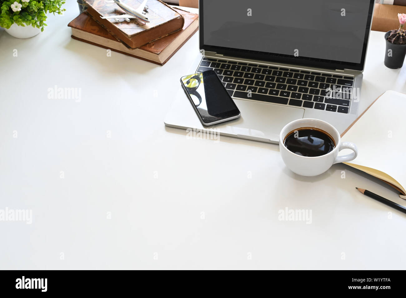 Office desk laptop, mobile, coffee and book with copy space top view ...