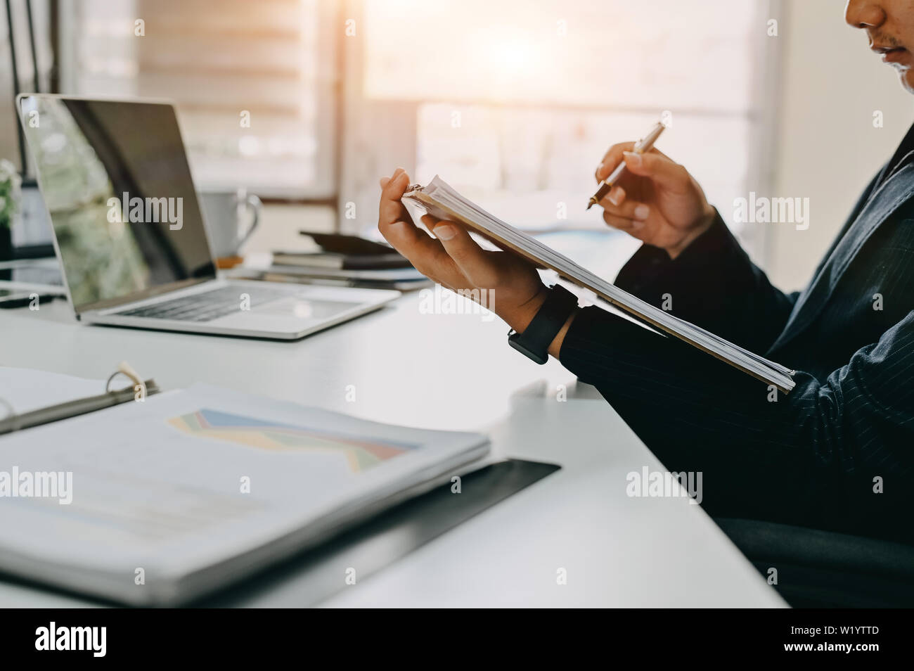 Audit working, Businessman work with paper document on clipping board in office. Stock Photo