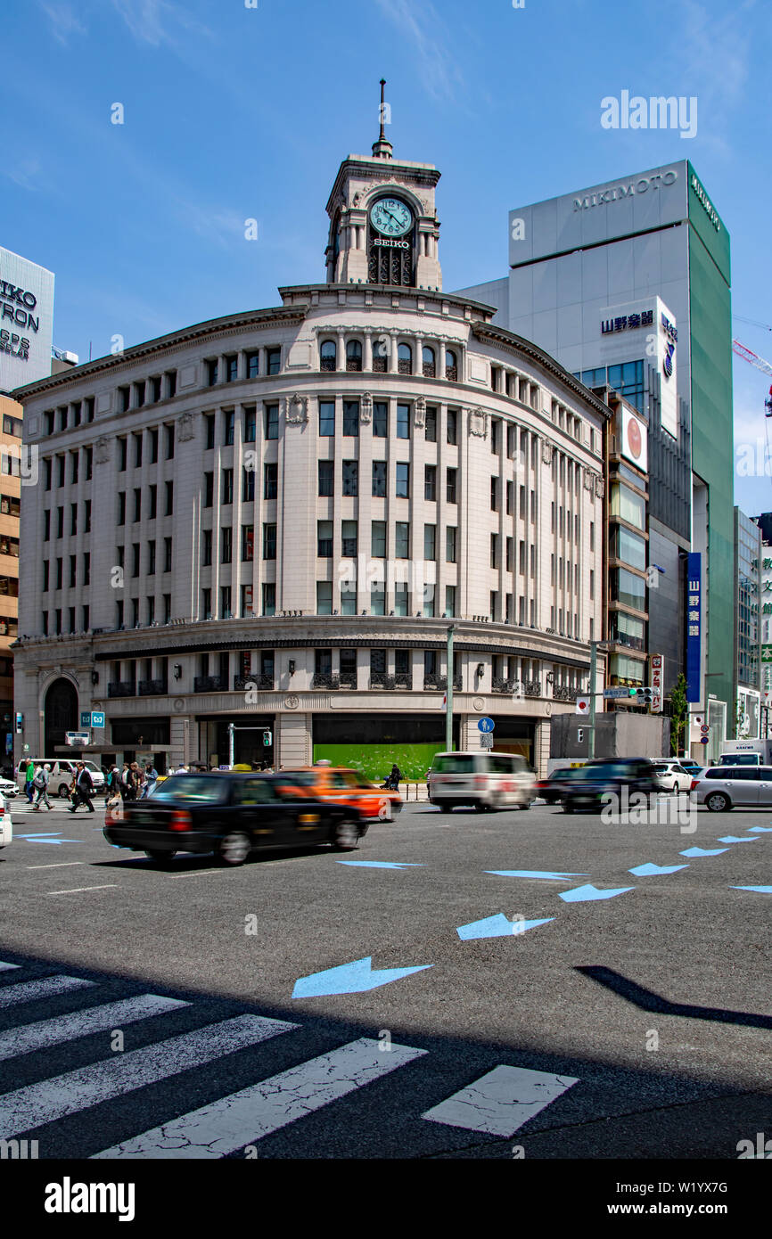 Traffic passes in front of the Wako Department Store with its iconic clock tower at the Ginza Yonchome crossing in Tokyo, Japan Stock Photo