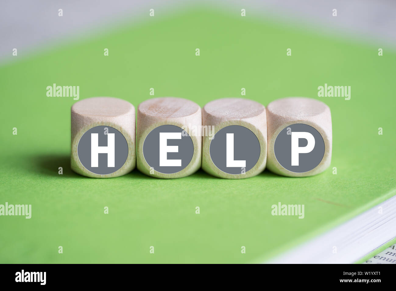 dice on a notebook forming the word HELP Stock Photo