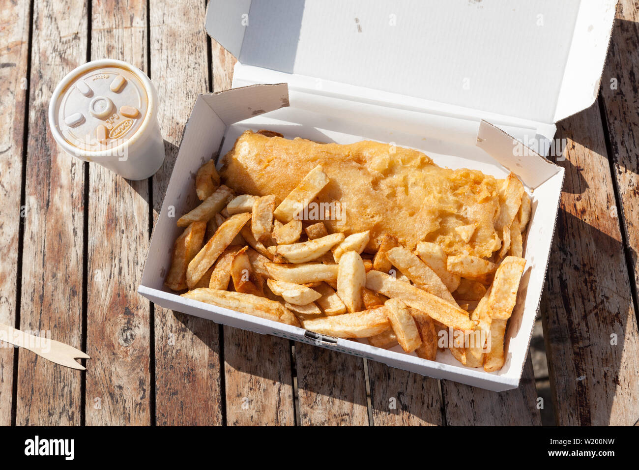 Traditional British Fish and Chips in a Box on a Wooden Table. Stock Photo