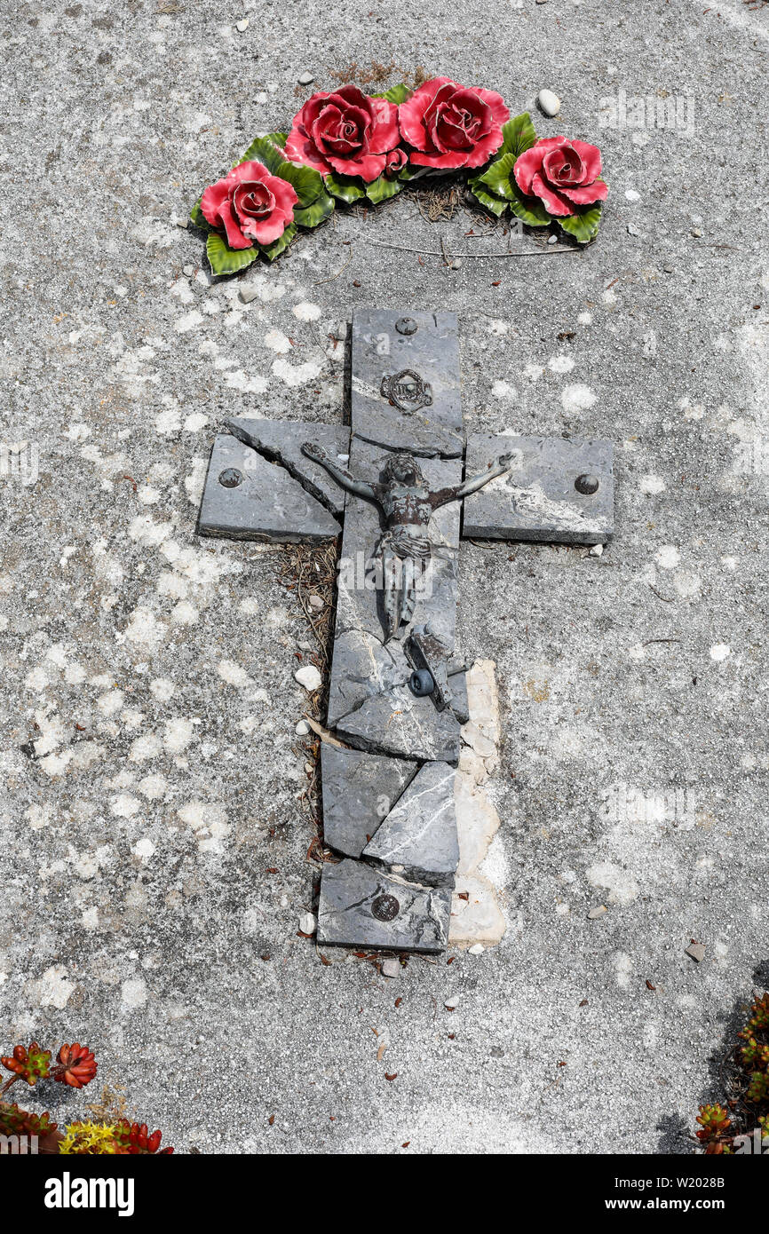 Broken crucifix on a gravestone in Cimetière de Saint-Paul-de-Vence, France Stock Photo