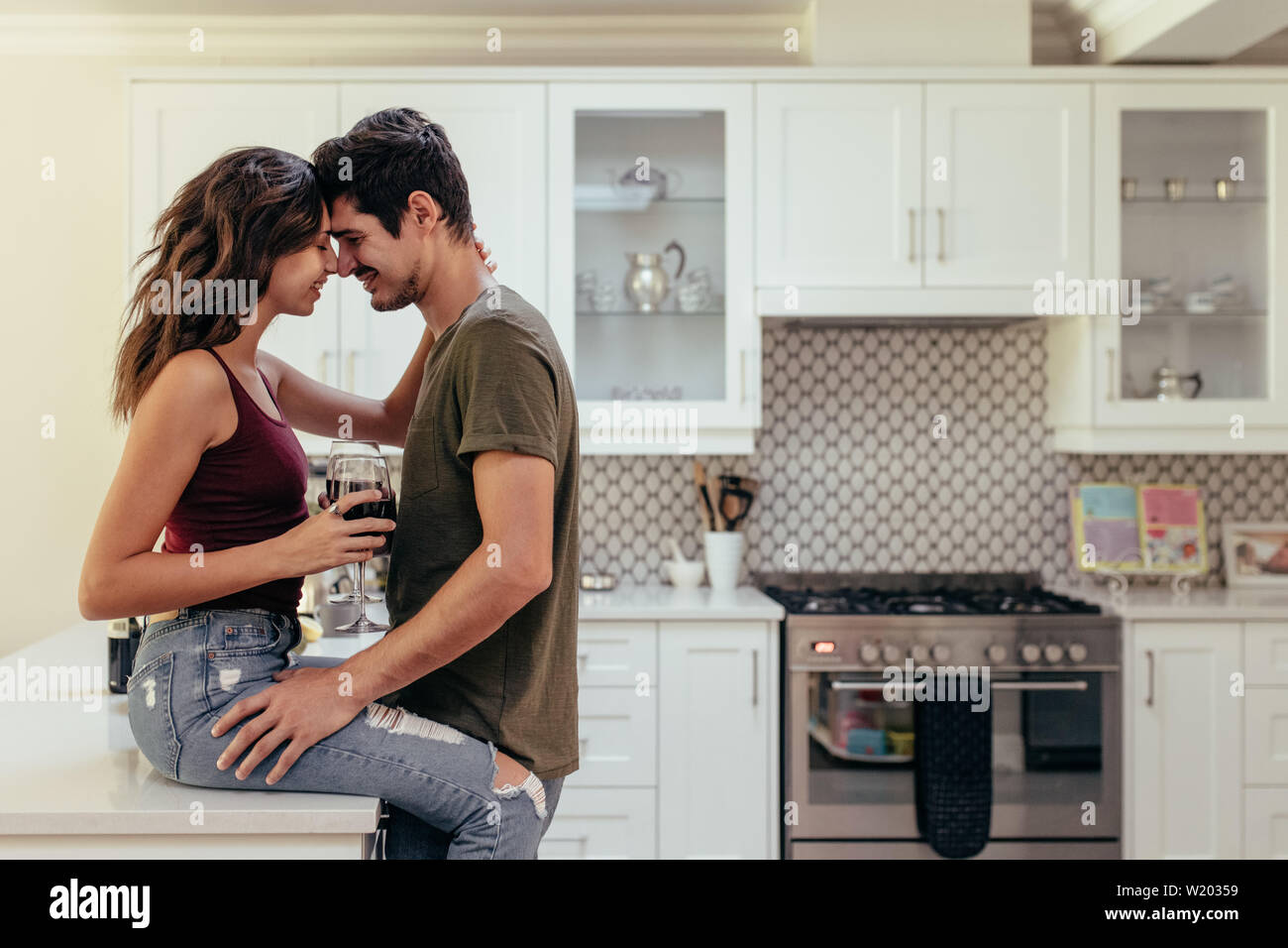 Attractive Passionate Couple In Kitchen Woman Is Sitting On