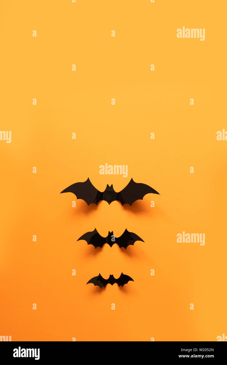 Creative top view halloween composition of black paper bats fly up on ...