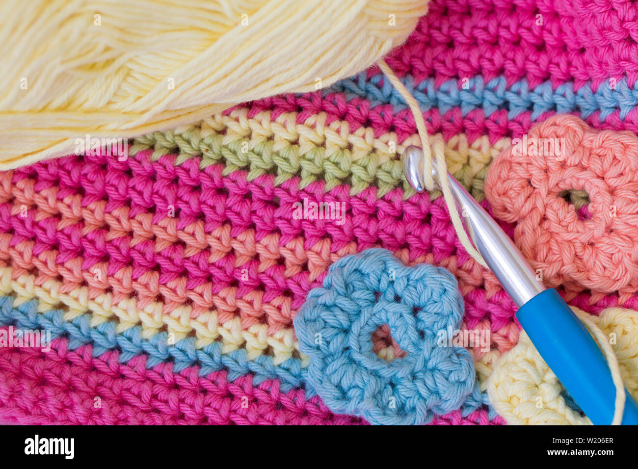 Crocheted colorful background with crochet hook and a wool ball Stock Photo