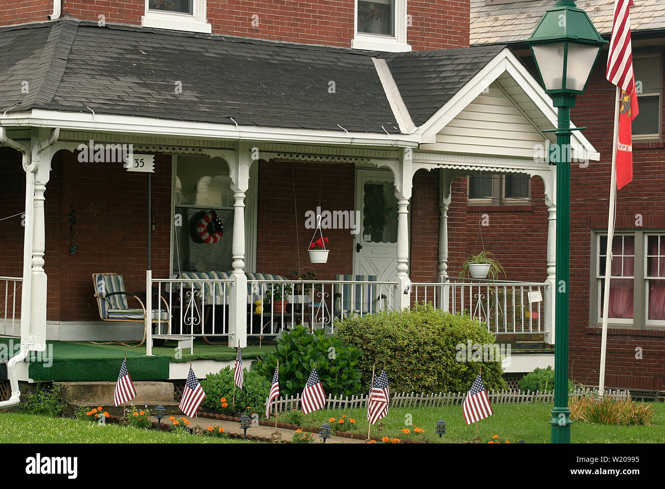 Modest house porch and yard decorated with U.S. flags in Pennsylvania, USA Stock Photo