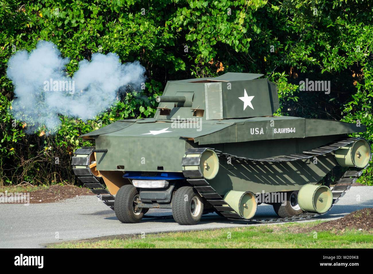 Sullivans Island South Carolina, USA. 4th July, 2019. A golf cart decorated as a military tank fires blanks from the cannon during the annual Independence Day parade July 4, 2019 in Sullivan's Island, South Carolina. The tank was a tongue-in-check reference to the controversy over the military parade in Washington. Credit: Planetpix/Alamy Live News Stock Photo