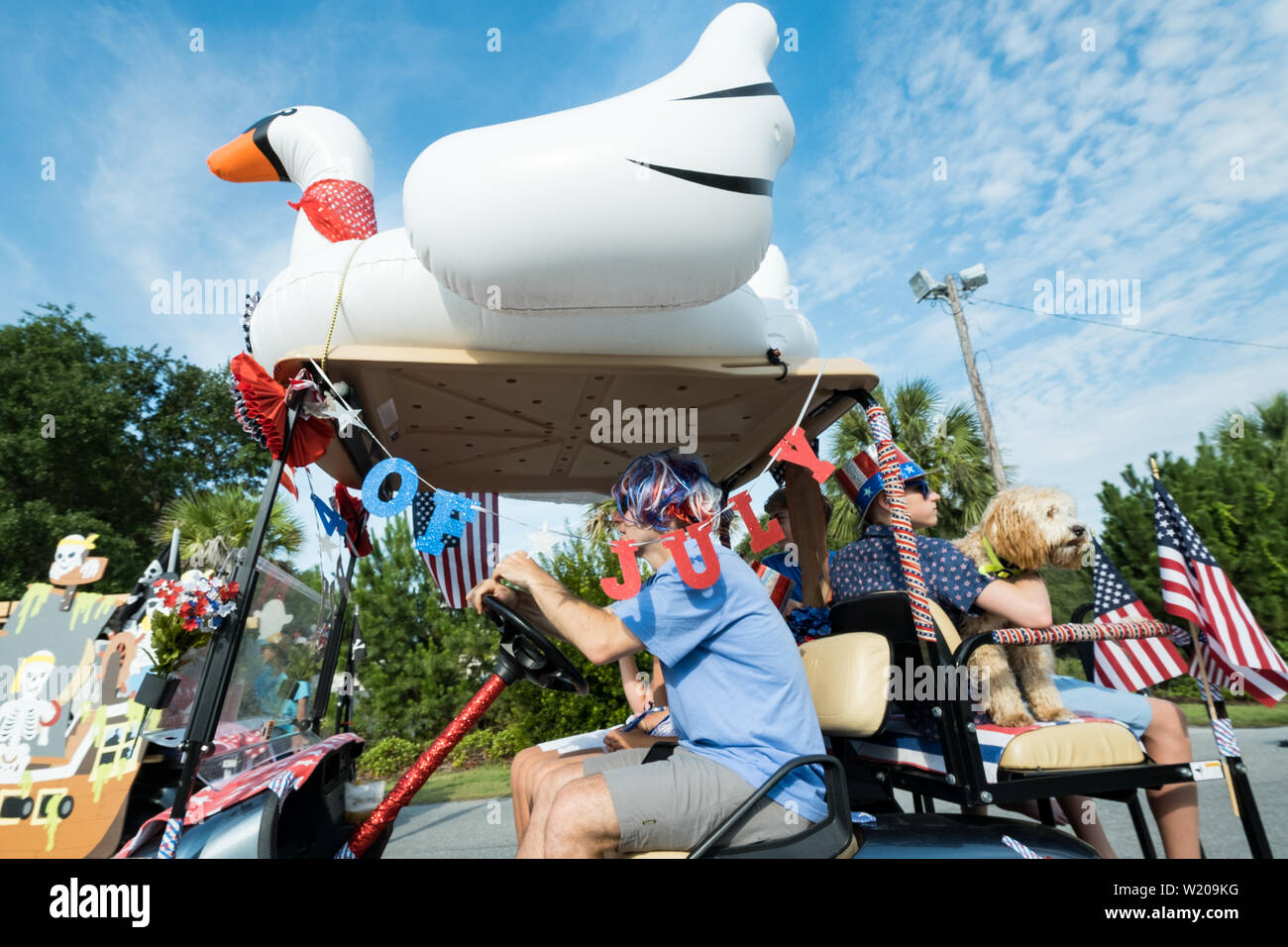 Sullivans Island South Carolina, USA. 4th July, 2019. A family drives their decorated golf cart float during the annual Independence Day parade July 4, 2019 in Sullivan's Island, South Carolina. The tiny affluent Sea Island beach community across from Charleston holds an outsized golf cart parade featuring more than 75 decorated carts. Credit: Planetpix/Alamy Live News Stock Photo