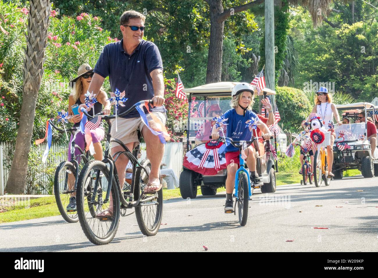 Sullivans Island South Carolina, USA. 4th July, 2019. Families take part in the annual Independence Day golf cart and bicycle parade July 4, 2019 in Sullivan's Island, South Carolina. The tiny affluent Sea Island beach community across from Charleston holds an outsized golf cart parade featuring more than 75 decorated carts. Credit: Planetpix/Alamy Live News Stock Photo