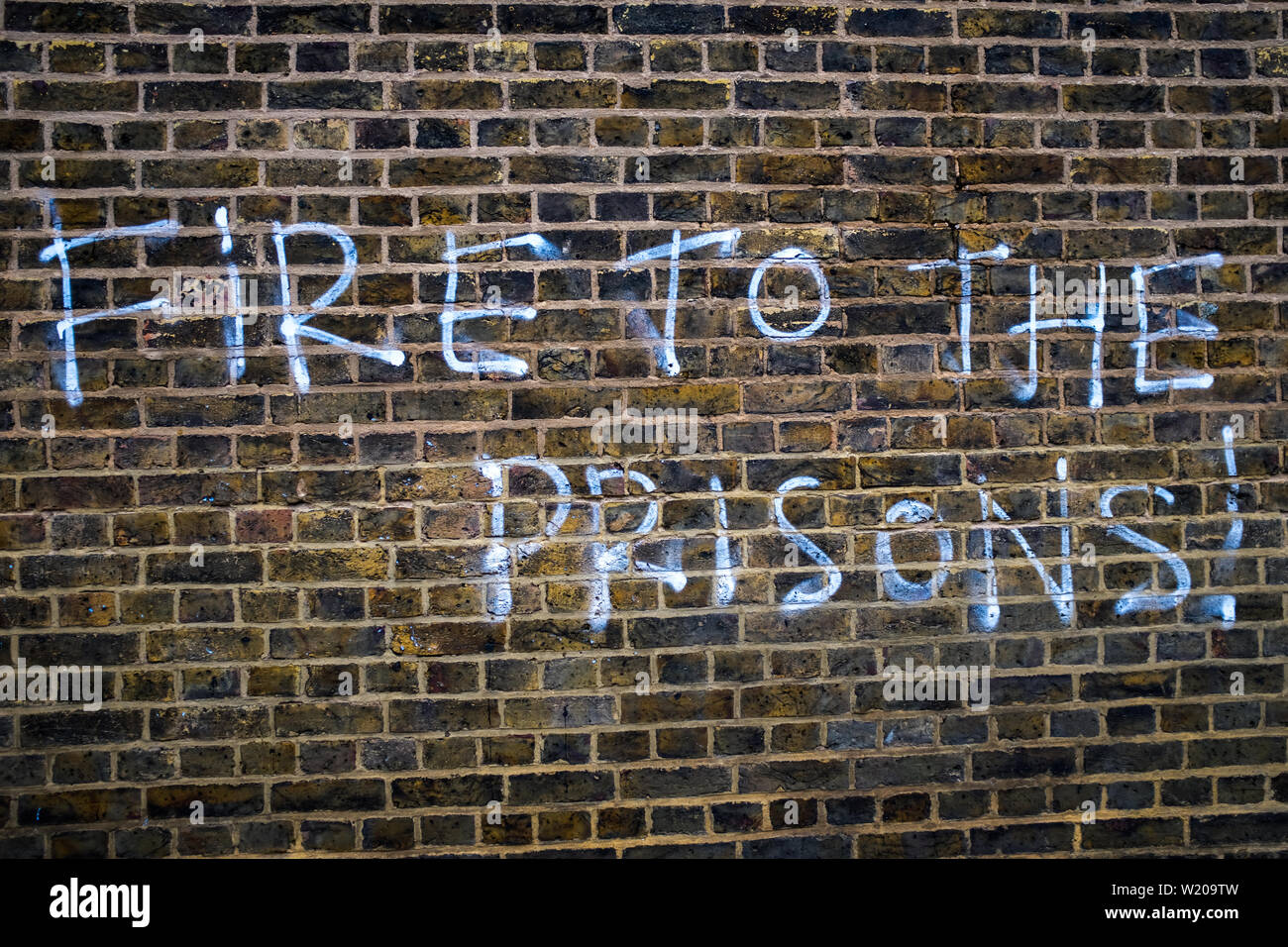 Fire to the Prisons graffiti spray-painted on Brixton Prison, Brixton, England. Stock Photo