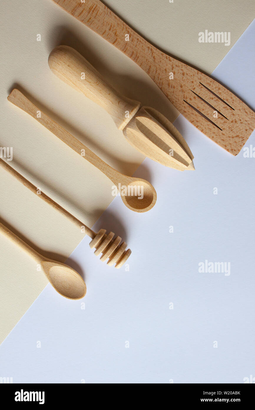 Handmade wooden cutlery on beige white background, wood kitchen tools. Stock Photo