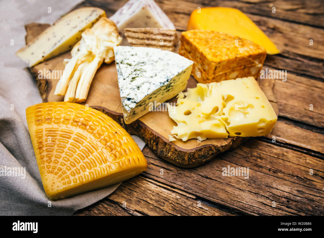 Assorted, various aged cheeses on plate or board. Different kind or