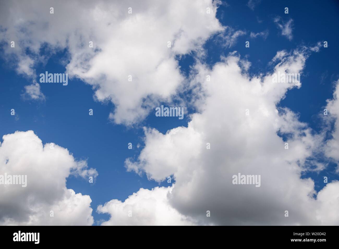 Beautiful white fluffy clouds on a deep blue sky background. Scenic sky ...