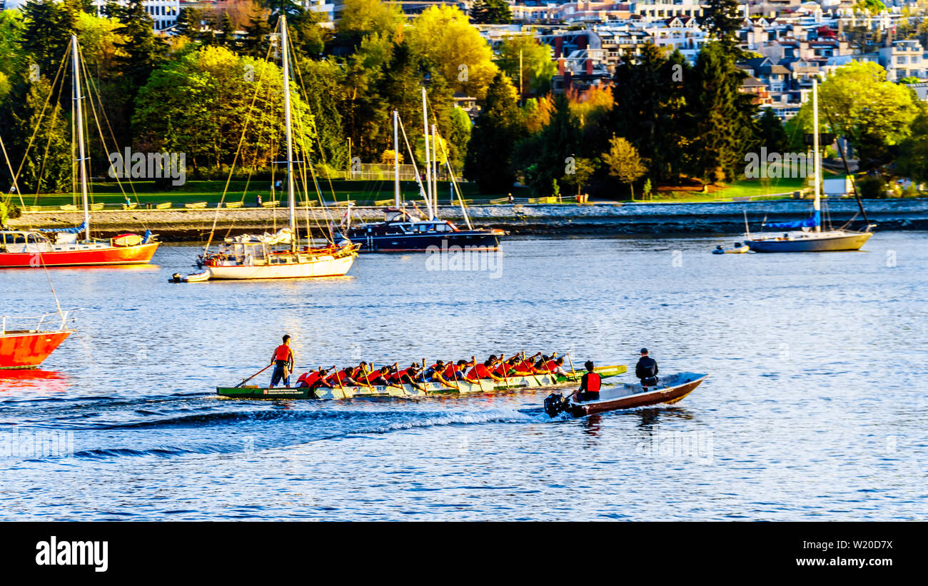 Dragon Boat practice in False Creek Inlet at sunset on a beautiful Spring Day in Vancouver, British Columbia, Canada Stock Photo