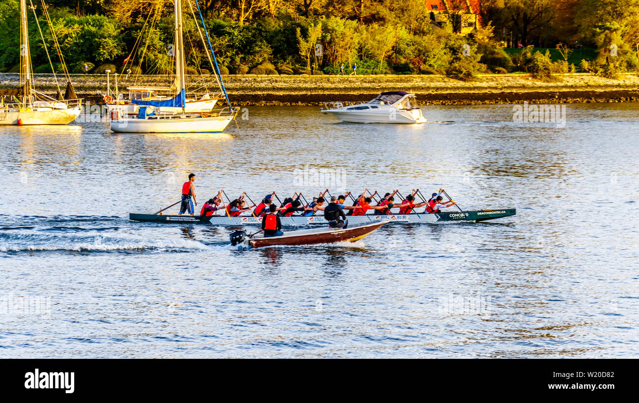 Dragon Boat practice in False Creek Inlet at sunset on a beautiful Spring Day in Vancouver, British Columbia, Canada Stock Photo