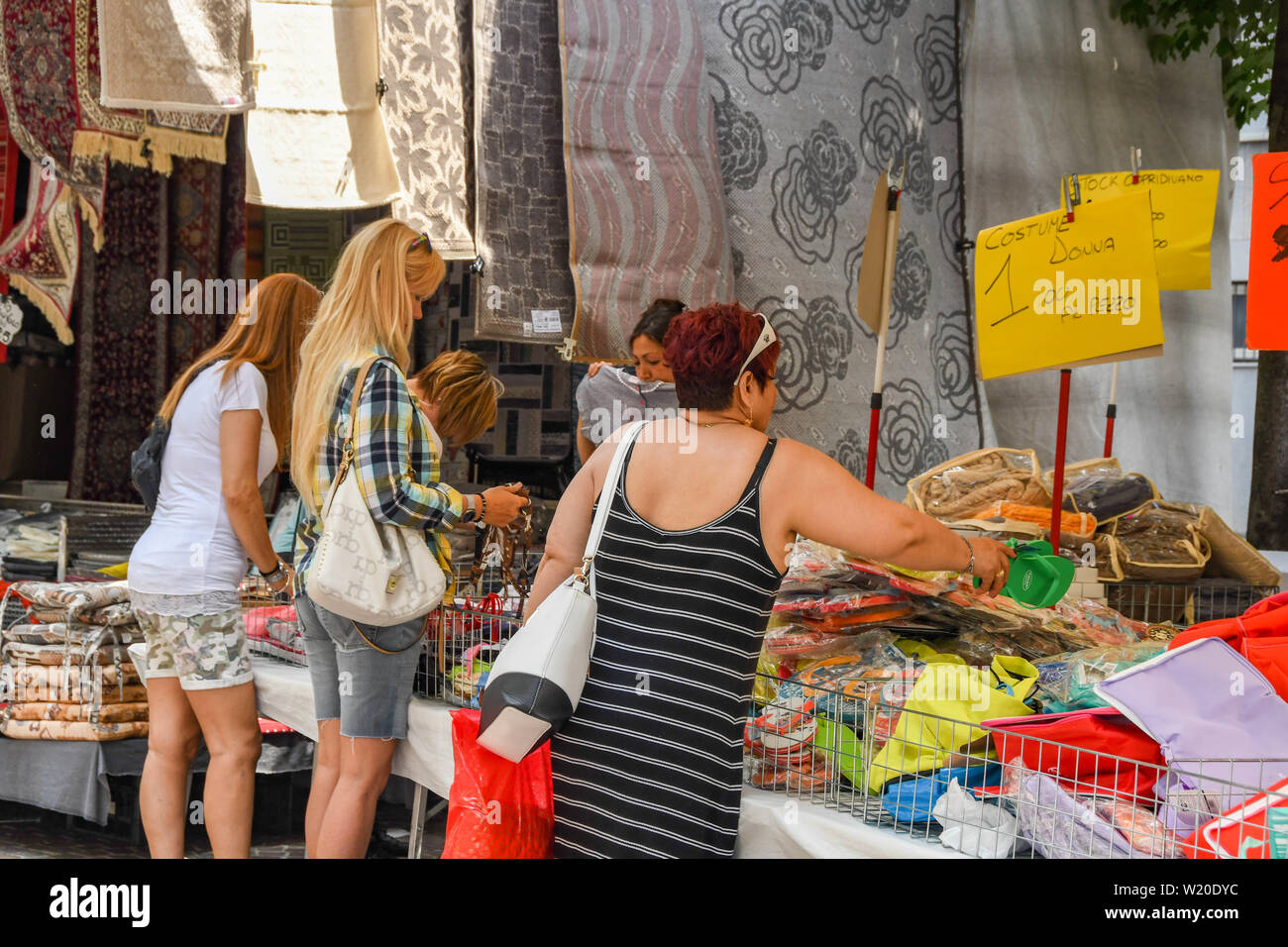COMO, ITALY - JUNE 2019: People looking at goods on a stall in the outdoor market in Como on Lake Como. Stock Photo