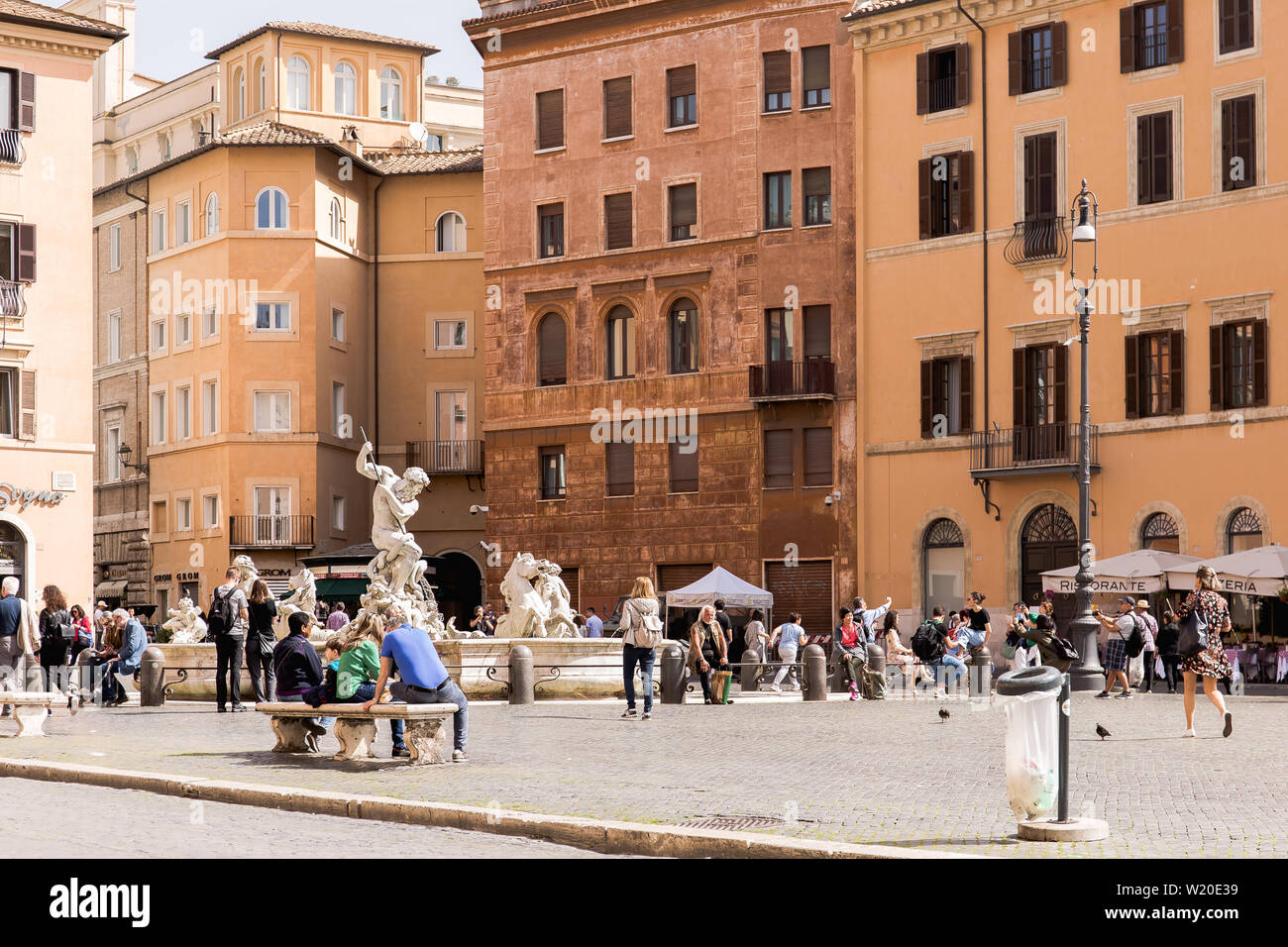 ROME, ITALY - APRIL 24, 2019: Tourists enjoying The Fountain of Neptune in Piazza Navona square on a sunny day. Happy tourists visiting italian famous Stock Photo